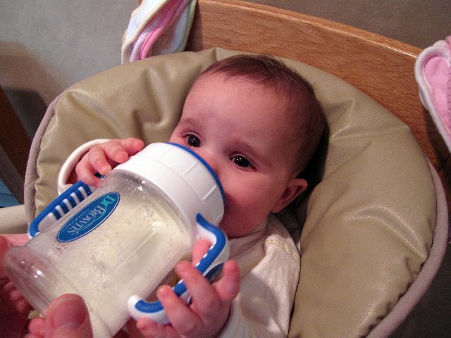 IMG_5111b.jpg - Attempt #1 to introduce the sippy cup .. didn't go so well because she wants to bite on everything, not sip.