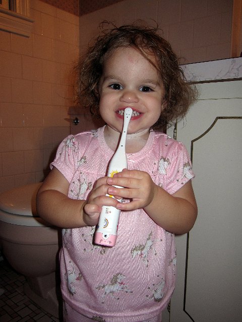 IMG_1390b.jpg - We thought perhaps if we bought her an electric toothbrush like the big people use, she'd be more willing to brush her teeth.  It was very cool and Mom spent a lot of time decorating it with stickers, etc. but she still preferred her original one.