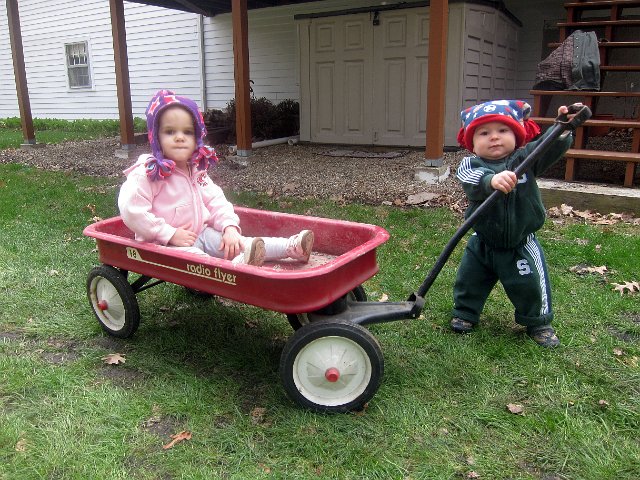 IMG_3274b.jpg - The kids were out playing with the wagon (notice who is pulling who) while Dad was working on leveling the stones for the play area.