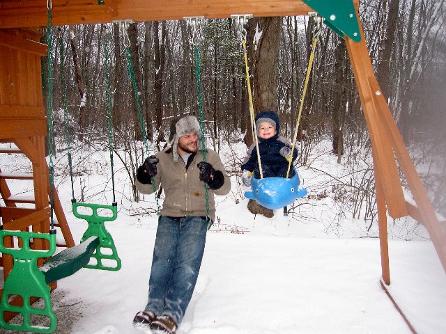 IMG_8036.jpg - When Nathan is wearing his snow boots, his feet won't fit into the dolphin swing.  But even that didn't stop him from getting Daddy to swing with him.