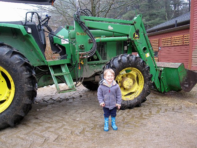 IMG_3874.jpg - This is Nathan's face when I ask him to 'smile'.  I wanted a photo in front of the tractor because he was very excited to hear it coming roaring around to the barn.
