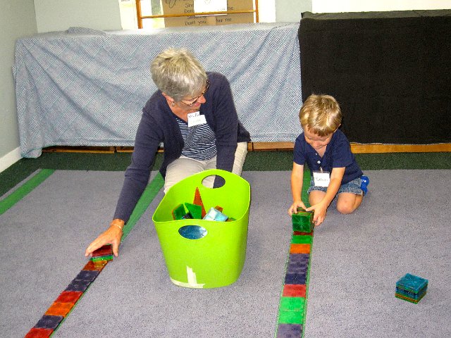 IMG_8088.jpg - He's making friends with one of his teachers while playing with one of his favorite toys, the MagnaTiles.
