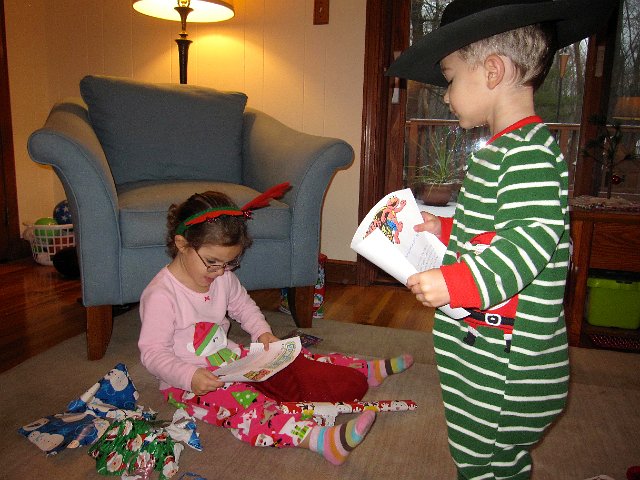 IMG_3347.jpg - Our Christmas morning kicks off with stocking stuffers while the monkey bread bakes and then we move onto the gifts under the Christmas tree.                   This particular gift is tickets for everyone to go see a Sesame Street Live show coming to town next month.                    (By the way, to explain the cowboy hat .. Nathan saw the rest of us raiding the dress-up bin for our elf, Santa and reindeer gear and came out wearing his cowboy hat.)